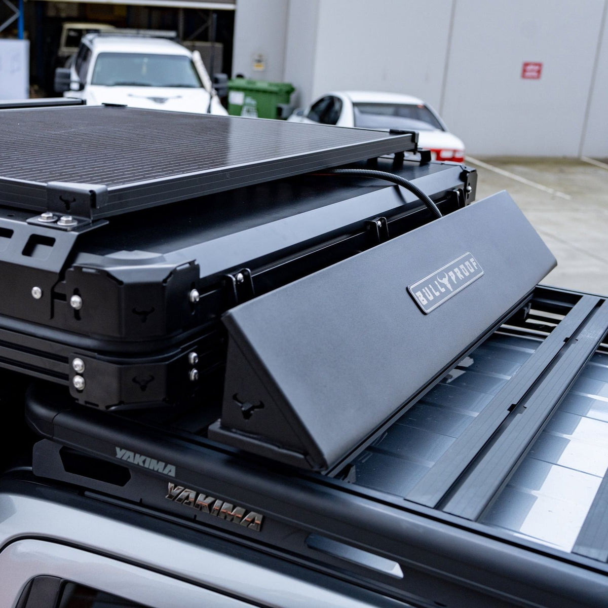 Rooftop tent wind deflector mounted to the front of a hardshell rooftop tent